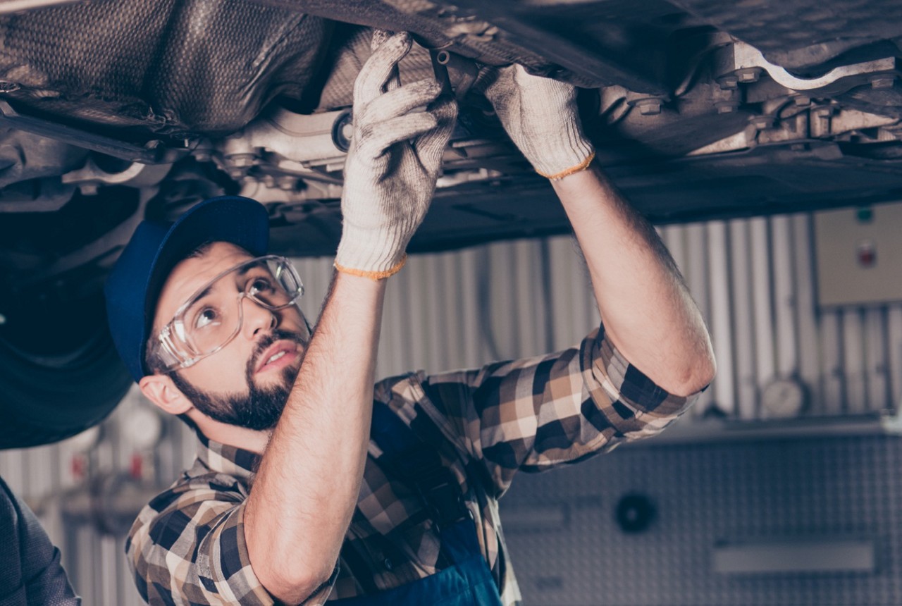 auto-technician-examining-vehicle-on-lift auto-technician-examining-vehicle-on-lift