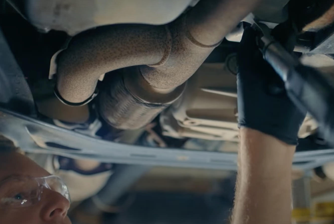 Mechanic installing oil pan on vehicle Mechanic installing oil pan on vehicle
